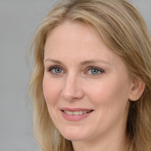 Joyful white adult female with long  brown hair and blue eyes