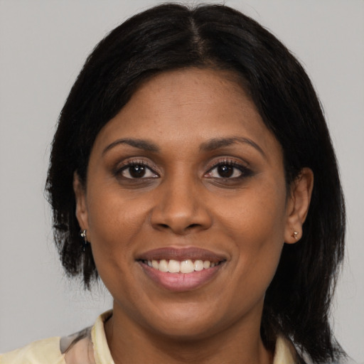 Joyful latino adult female with medium  black hair and brown eyes