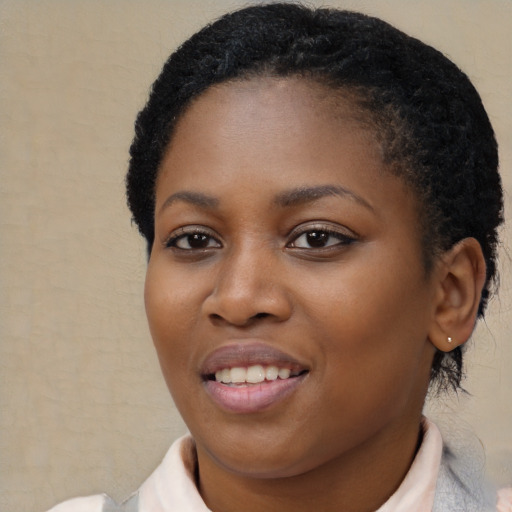 Joyful black young-adult female with short  black hair and brown eyes