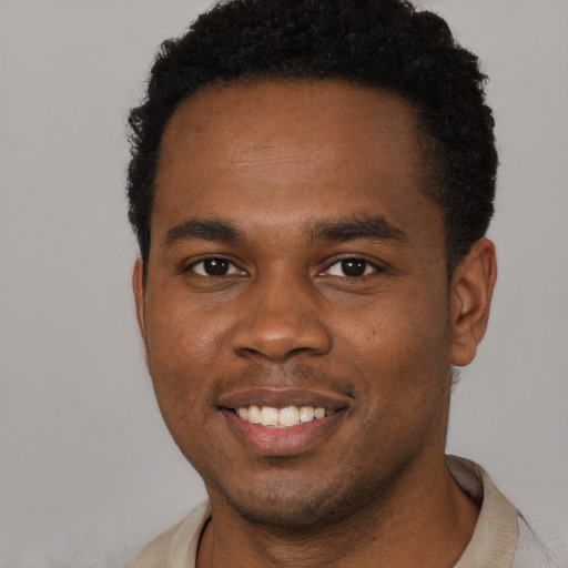 Joyful black young-adult male with short  brown hair and brown eyes