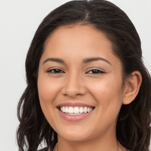 Joyful latino young-adult female with long  brown hair and brown eyes