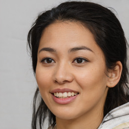 Joyful latino young-adult female with medium  brown hair and brown eyes