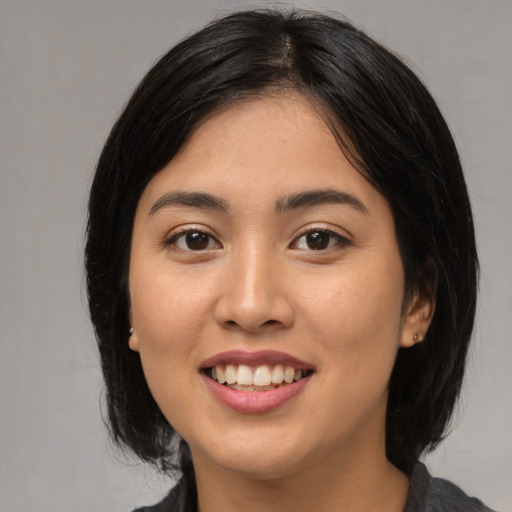 Joyful asian young-adult female with medium  brown hair and brown eyes