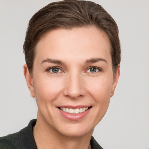 Joyful white young-adult female with short  brown hair and grey eyes