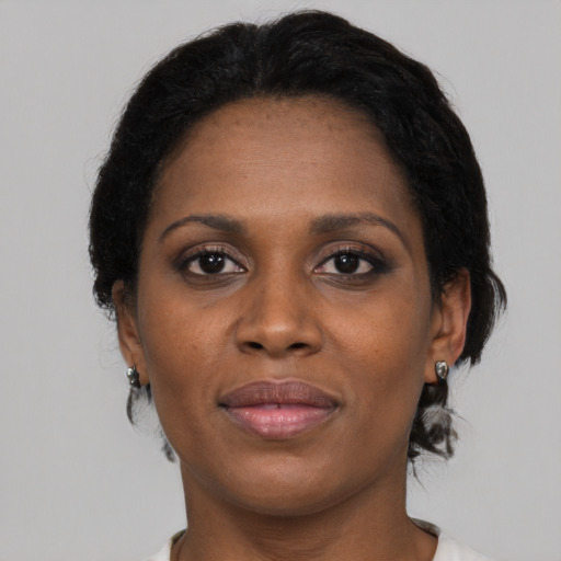 Joyful black adult female with medium  brown hair and brown eyes