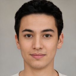 Joyful latino young-adult male with short  brown hair and brown eyes