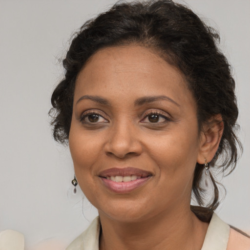 Joyful latino adult female with medium  brown hair and brown eyes