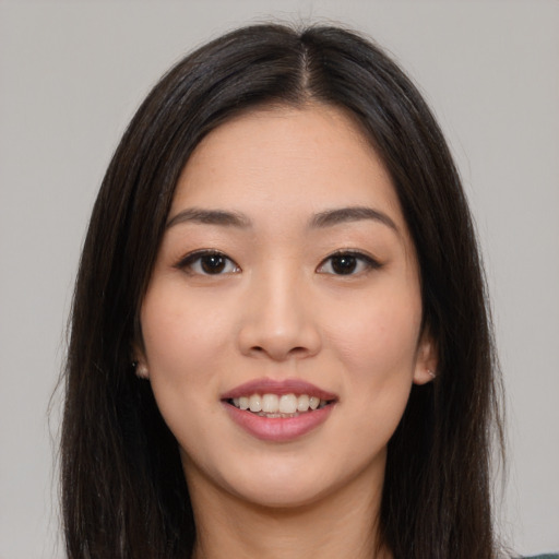 Joyful asian young-adult female with long  brown hair and brown eyes