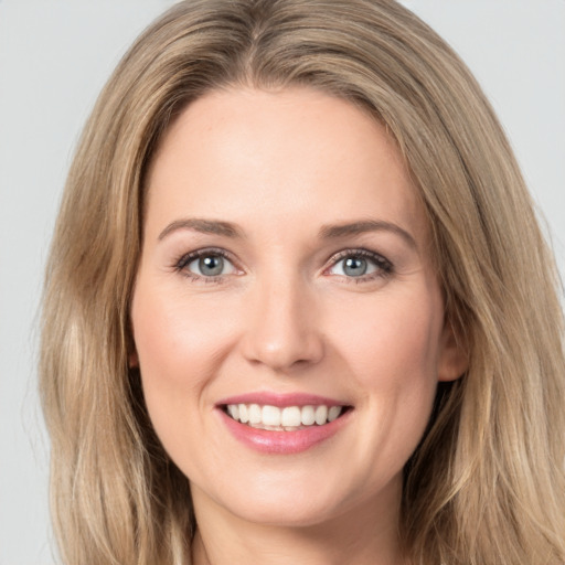 Joyful white young-adult female with long  brown hair and green eyes