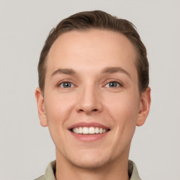 Joyful white young-adult male with short  brown hair and grey eyes