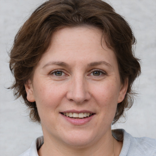 Joyful white adult female with medium  brown hair and grey eyes