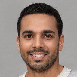 Joyful latino young-adult male with short  black hair and brown eyes