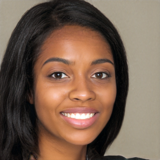 Joyful black young-adult female with long  brown hair and brown eyes