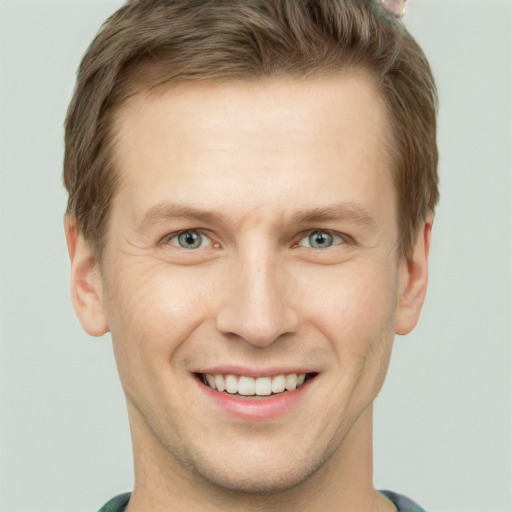 Joyful white young-adult male with short  brown hair and green eyes