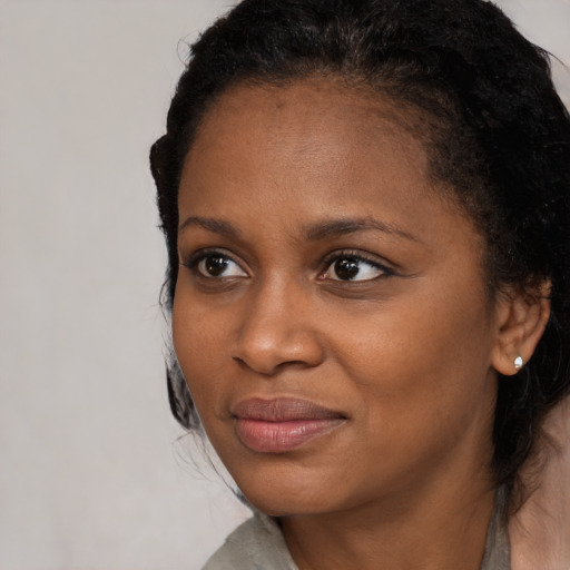 Joyful black young-adult female with medium  brown hair and brown eyes