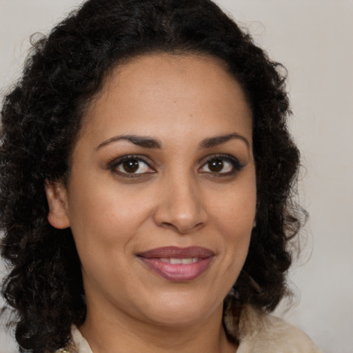 Joyful latino adult female with medium  brown hair and brown eyes