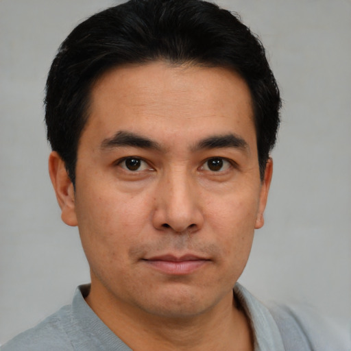 Joyful asian young-adult male with short  brown hair and brown eyes
