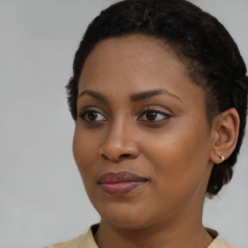 Joyful black young-adult female with short  brown hair and brown eyes