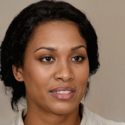 Joyful black young-adult female with medium  brown hair and brown eyes
