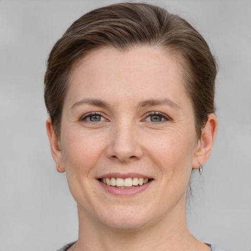 Joyful white young-adult female with short  brown hair and grey eyes