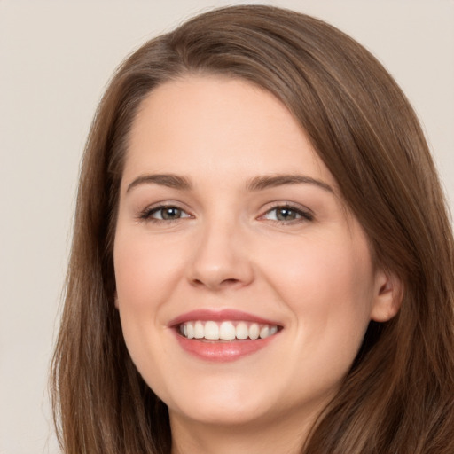 Joyful white young-adult female with long  brown hair and brown eyes