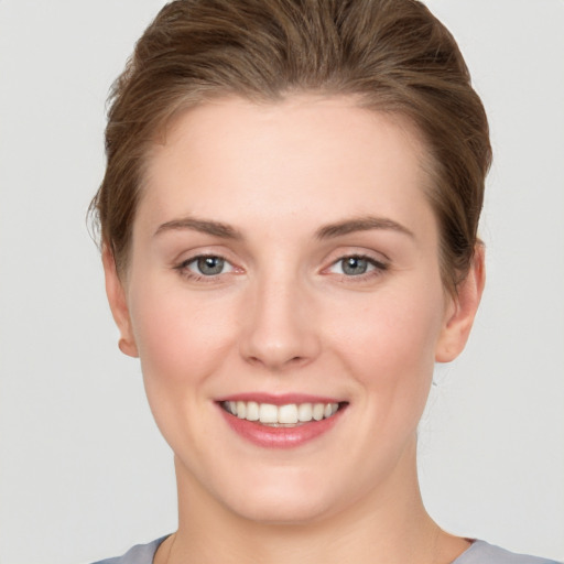 Joyful white young-adult female with short  brown hair and grey eyes