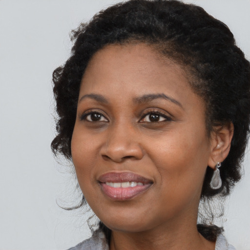 Joyful black young-adult female with medium  black hair and brown eyes