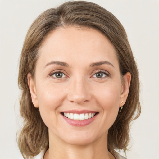 Joyful white young-adult female with medium  brown hair and grey eyes