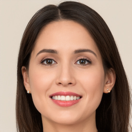 Joyful white young-adult female with long  brown hair and brown eyes