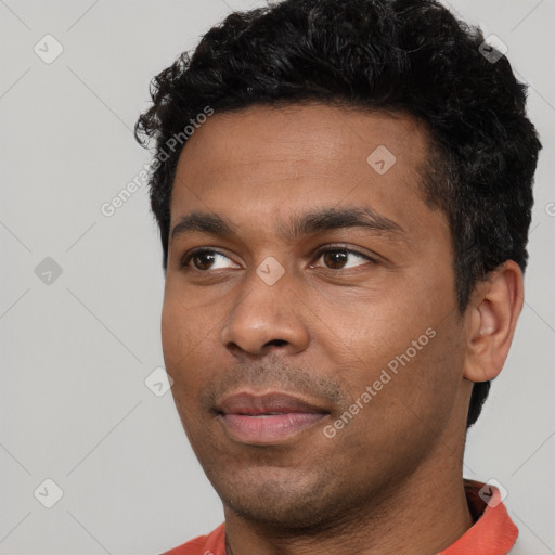 Joyful black young-adult male with short  black hair and brown eyes