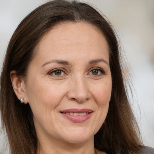 Joyful white adult female with long  brown hair and brown eyes