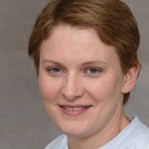 Joyful white adult female with short  brown hair and blue eyes