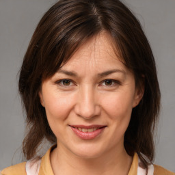 Joyful white adult female with medium  brown hair and brown eyes