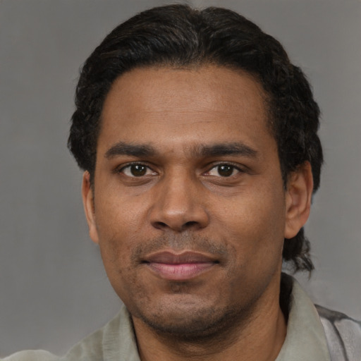 Joyful black adult male with short  black hair and brown eyes