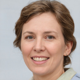 Joyful white adult female with medium  brown hair and grey eyes