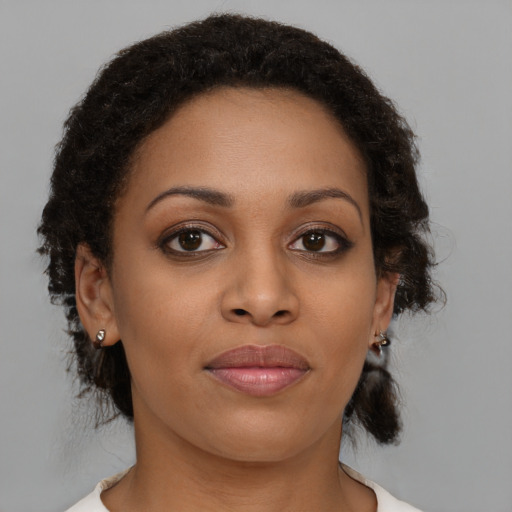 Joyful black young-adult female with medium  brown hair and brown eyes