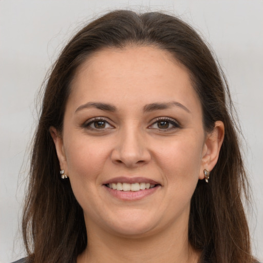 Joyful white young-adult female with long  brown hair and brown eyes