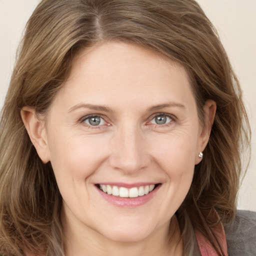 Joyful white adult female with medium  brown hair and grey eyes