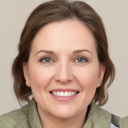 Joyful white adult female with medium  brown hair and green eyes