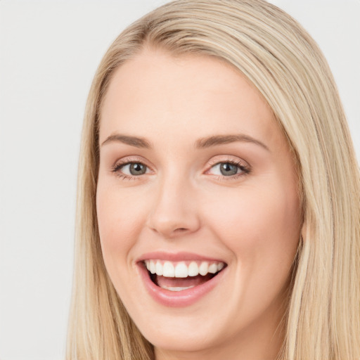 Joyful white young-adult female with long  brown hair and blue eyes