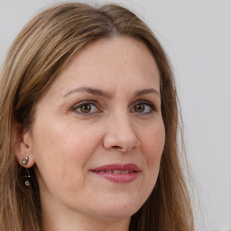 Joyful white adult female with long  brown hair and grey eyes