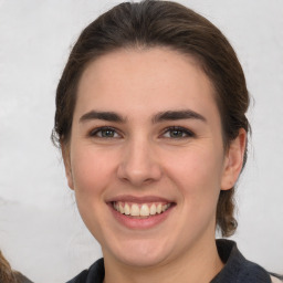 Joyful white young-adult female with medium  brown hair and grey eyes