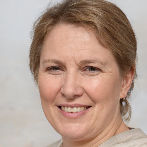 Joyful white middle-aged female with medium  brown hair and blue eyes