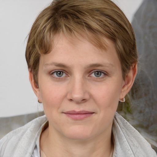 Joyful white young-adult female with medium  brown hair and grey eyes