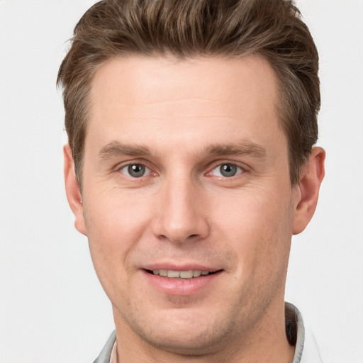 Joyful white young-adult male with short  brown hair and grey eyes