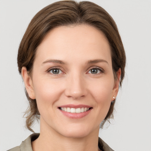 Joyful white young-adult female with medium  brown hair and grey eyes