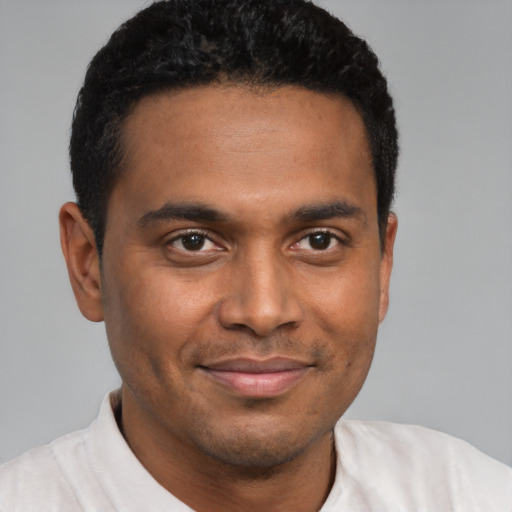 Joyful black young-adult male with short  brown hair and brown eyes