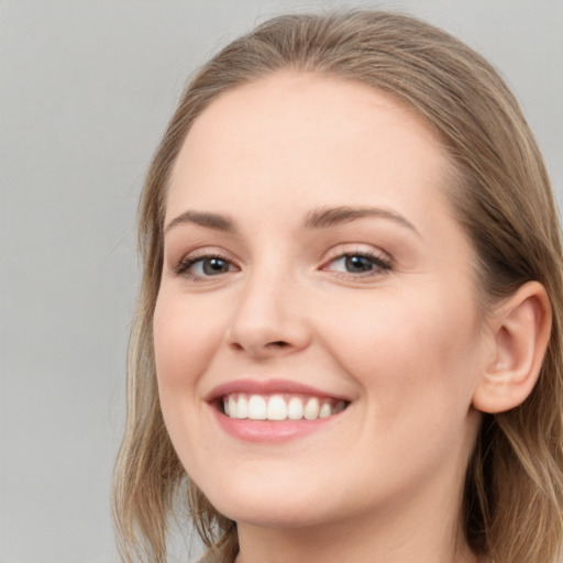 Joyful white young-adult female with long  brown hair and blue eyes