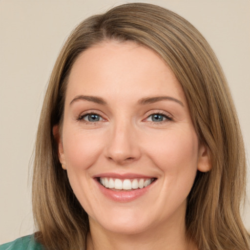 Joyful white young-adult female with long  brown hair and green eyes