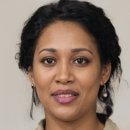 Joyful latino adult female with medium  brown hair and brown eyes